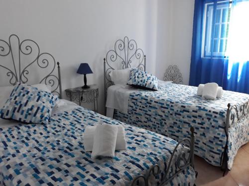 米尔芳提斯城Casa da Zi的一间卧室配有两张带蓝白色床单的床