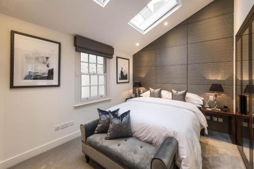伦敦Spectacular Knightsbridge House Harrods 1 minute的一间卧室配有一张大床和一张沙发