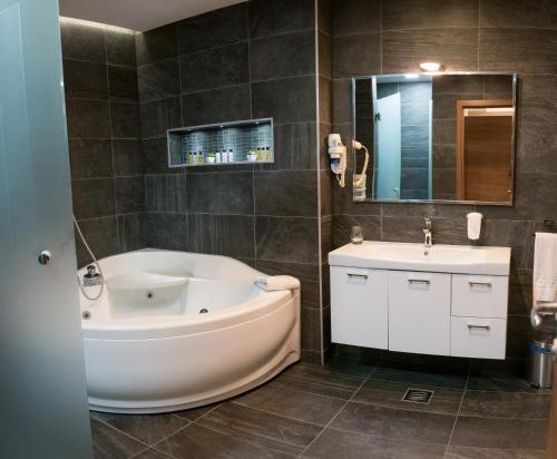 巴尼亚卢卡伊莲娜酒店的一间带大浴缸和水槽的浴室