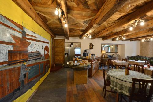 奥斯塔Vecchio Mulino Guest House的餐厅设有木制天花板和桌椅