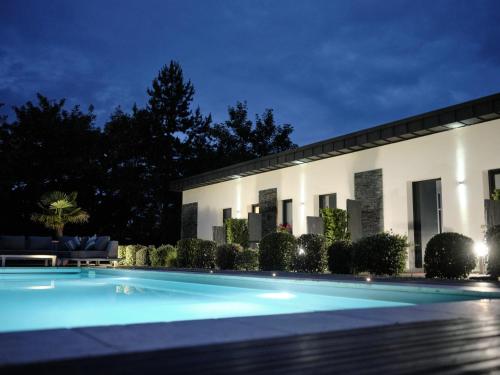 阿尔让唐Hostellerie de la Renaissance - Teritoria的一座游泳池,在晚上在建筑物前