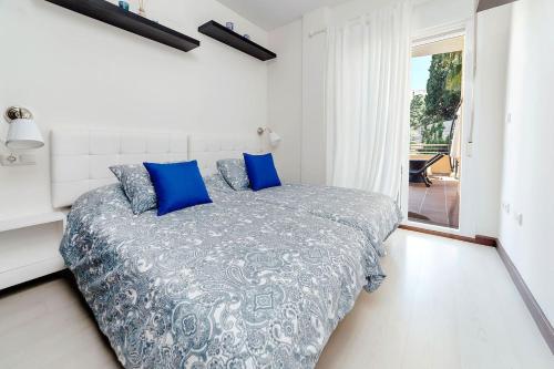 阿尔姆尼卡Cotobro Rental House的一间卧室配有一张带蓝色枕头的床和一扇窗户。