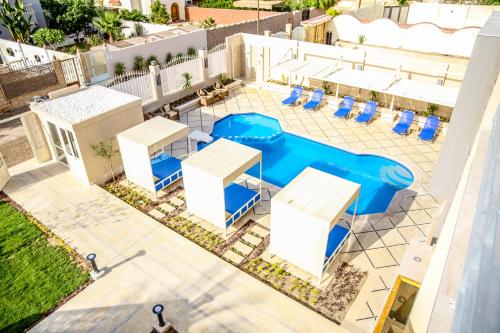 赫尔格达Serenity Home Hurghada的享有带桌椅的游泳池的顶部景致
