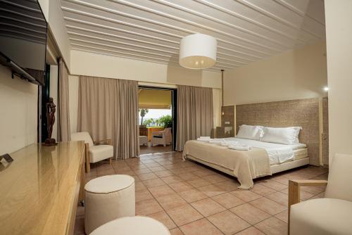 瓦西里科斯Ammos Beachfront Confortable Rooms - Adults only的酒店客房配有一张床铺和一张桌子。