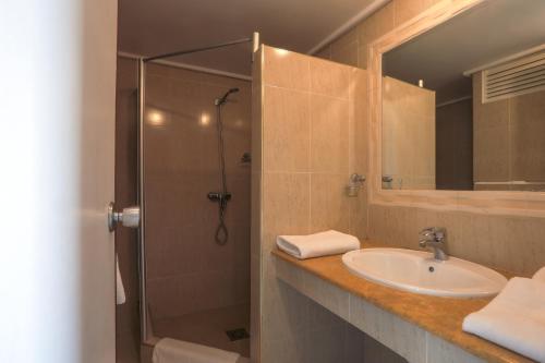 丹吉尔UMH Tarik Hotel的带淋浴、盥洗盆和镜子的浴室