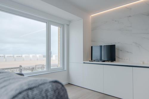 科克赛德Studio Koksijde的一间卧室设有大窗户和电视