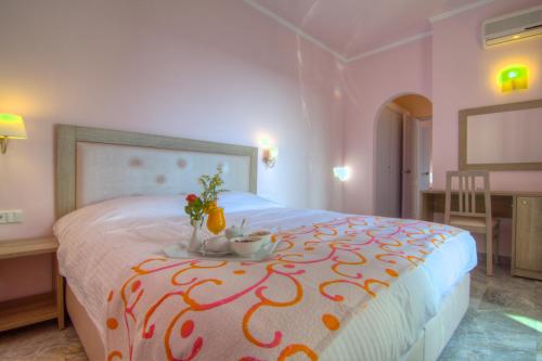 阿德里安诺斯坎波斯Solimar Dias Hotel的一间卧室配有一张带鲜花桌的床