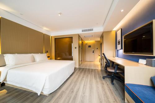 延安延安枣园亚朵酒店的酒店客房设有一张白色大床和一张书桌
