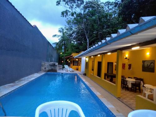 佩鲁伊比Guaraú Praia Suítes的房屋旁带椅子的游泳池