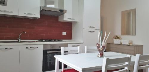博尔塞纳La Casa di Alberto的厨房配有白色的桌子和白色的椅子
