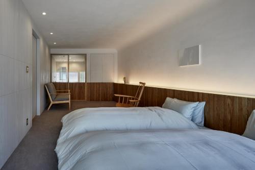 仓敷滔々 御崎 二階の宿 toutou Onzaki Nikai no Yado的卧室配有一张白色大床和一把椅子