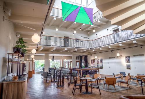 索尔纳阿斯普伦第二家园公寓的餐厅设有桌椅和色彩缤纷的雨伞