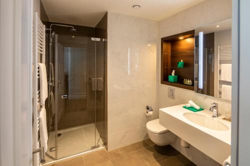 汉堡Fraser Suites Hamburg的带淋浴、卫生间和盥洗盆的浴室
