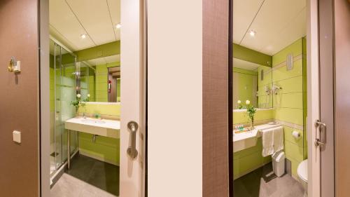巴塞罗那Bonanova Suite的绿色浴室设有两个水槽和镜子