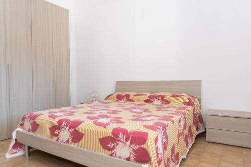 新福卡Villa Limoni 7 posti letto - San Foca的一间卧室配有一张带红色和黄色毯子的床