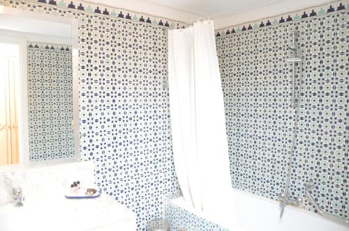 乌姆苏克Dar El Manara Djerba Hotel & Aparts的浴室设有蓝色和白色瓷砖淋浴帘