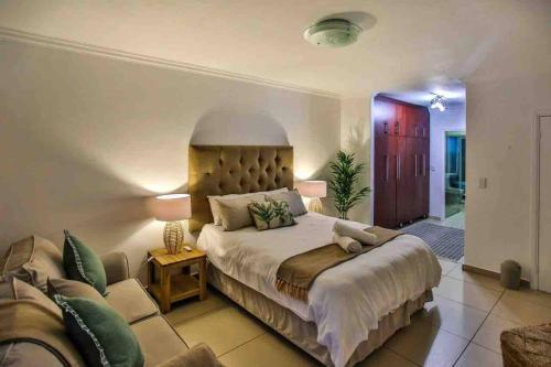 巴利托Komorebi Ballito的一间卧室配有一张大床和一张沙发