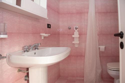 新福卡Villa Runchia a 500 mt dal mare - San Foca的粉红色的浴室设有水槽和卫生间