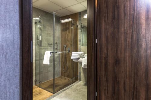 什切青伏尔甘酒店的浴室设有玻璃淋浴间和卫生间