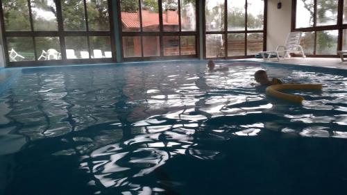 格拉玛多Residencial Pousada Serrano的在游泳池游泳的人