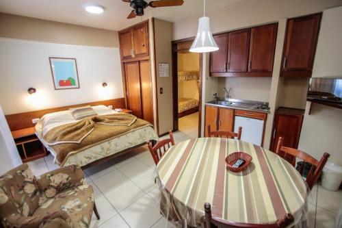 格拉玛多Residencial Pousada Serrano的配有床和桌子的房间以及厨房