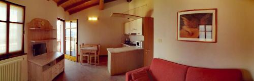 布雷佐内加尔达Residenza Cristina的一间带红色沙发的客厅和一间厨房