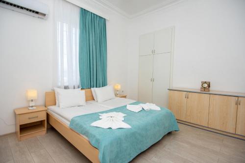 第比利斯洛厄尔酒店的一间卧室配有一张床,上面有两条毛巾