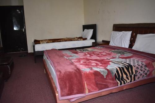 伊斯兰堡Hotel Islamabad Residency的一间卧室配有两张带红毯的床