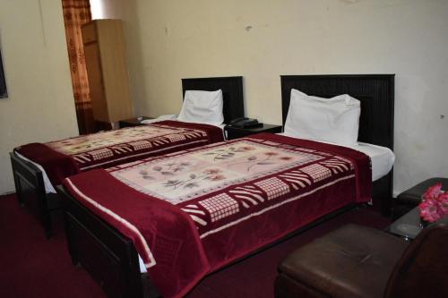 伊斯兰堡Hotel Islamabad Residency的两张睡床彼此相邻,位于一个房间里