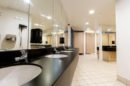 都柏林Generator Dublin的一间带三个水槽和大镜子的浴室