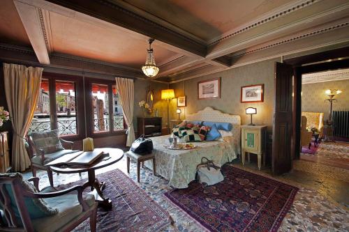 威尼斯大运河皮萨尼宫酒店的卧室配有一张床和一张桌子及椅子