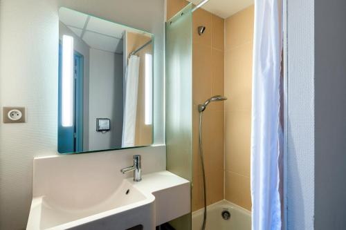 绍莱B&B HOTEL Cholet Sud的一间带水槽、镜子和淋浴的浴室
