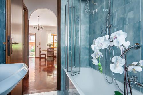 罗马Olympic Suite Roma的浴室配有浴缸和白色花卉淋浴