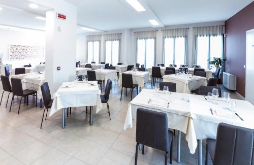 ElmasMansio Residence & Hotel的餐厅设有白色的桌椅和窗户。