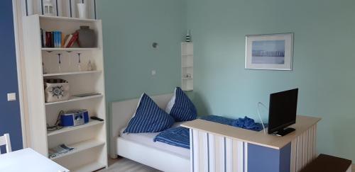 RambinFEWO Familie Hentschel的客房配有一张带蓝色枕头的床和一张书桌。