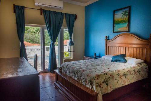 西区West End Dive Resort的一间卧室配有一张蓝色墙壁的床和一扇窗户