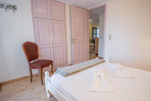 KávallosVilla Livas的一间卧室配有一张床、镜子和椅子
