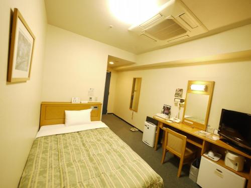 大阪大阪本町路线客栈酒店的客房设有床、书桌和电视。
