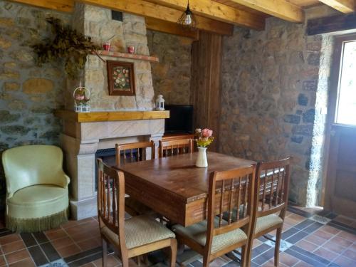 坎加斯-德奥尼斯Casa de Aldea La Xunta的一间带桌椅和壁炉的用餐室