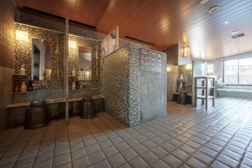 盛冈Dormy Inn Morioka的带淋浴的浴室和瓷砖墙