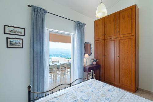 古卡斯特隆Villa Aiolos的一间卧室设有一张床和一个大窗户