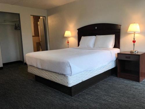波特兰Portland Super Value Inn的一张大床,位于酒店带两盏灯的房间