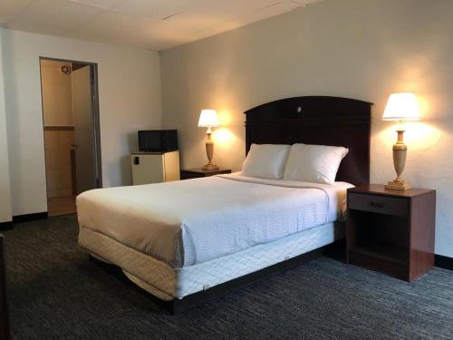 波特兰Portland Super Value Inn的酒店客房设有一张大床和两盏灯