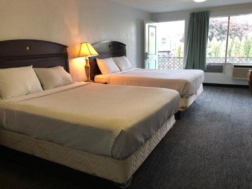 波特兰Portland Super Value Inn的酒店客房设有两张床和窗户。