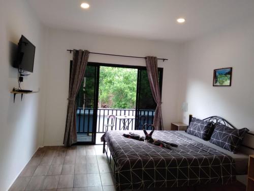 塔林甘海滩Samui Hills的一间卧室设有一张床,阳台配有电视。