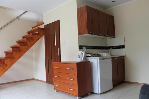 达尔沃沃Agroturystyka Rewita的一间带木制橱柜和楼梯的厨房
