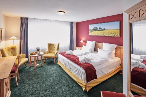 卡尔滕基尔兴桌克林商务水疗度假酒店的酒店客房设有一张大床和一张书桌。