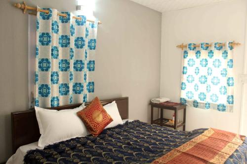 新德里Comfort Point Bed & Breakfast的一间卧室配有床和蓝白色窗帘