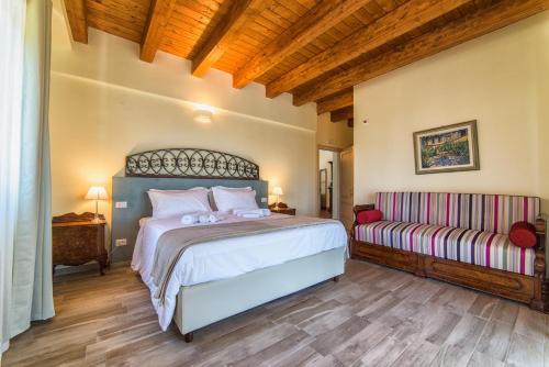 布德里奥Agriturismo Podere Amati的一间卧室配有一张大床和一张沙发