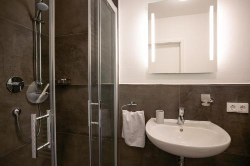 加兹尤瑟多姆Appartement "Saphir" mit Penthouseflair - Oase am Haff的一间带水槽和玻璃淋浴的浴室